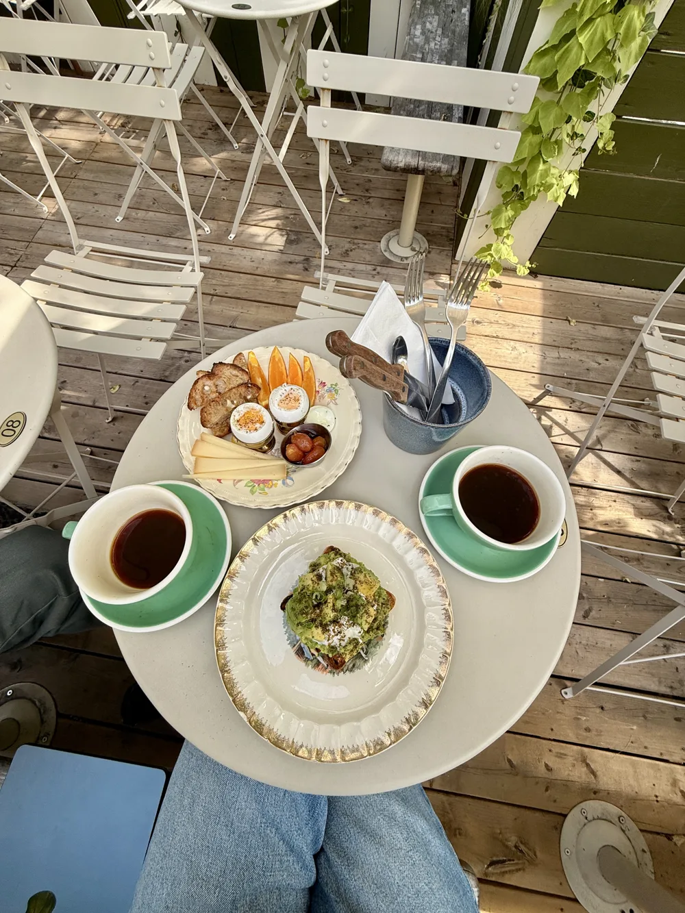 Breakfast table on a sunlit terrace, coffee poured