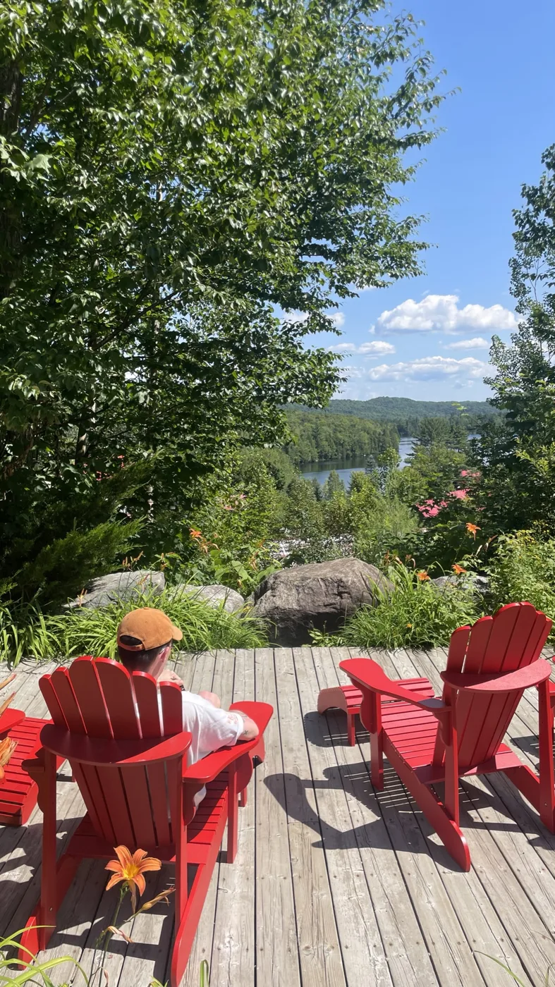 Red Adirondack chairs on a deck above the lake